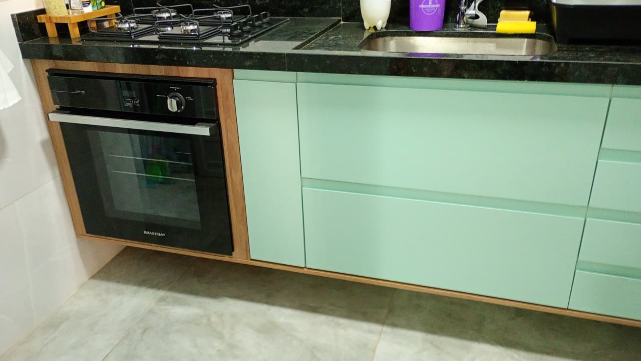 Cozinha verde com bancada preta